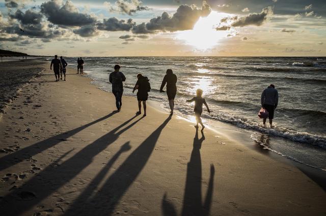 Family walk along a beach at nightfall